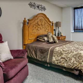 A cozy bedroom with a wooden headboard and patterned bedding.