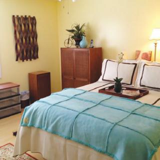 A cozy bedroom with a neatly made bed, soft lighting, and stylish decor.