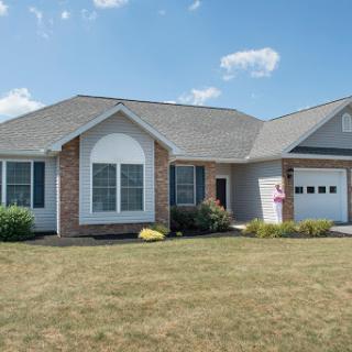 A charming single-story house with a neatly landscaped front yard.