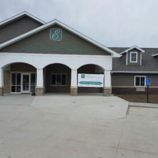 A medical clinic building with an entrance and parking lot.
