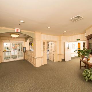 A well-lit hotel lobby with a carpeted floor and a reception area.