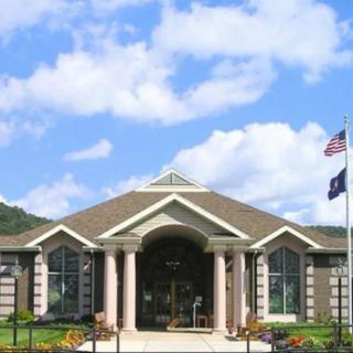 A modern building with flags and a clear blue sky.
