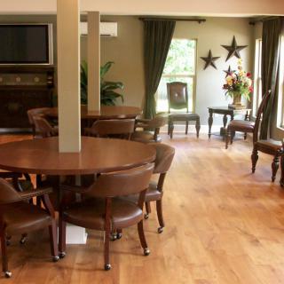 A spacious dining area with wooden flooring and elegant furniture.
