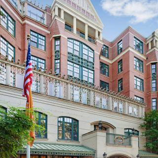 A multi-story brick hotel with large windows and flags displayed outside.