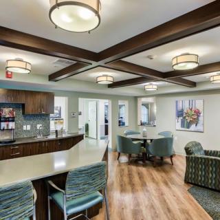 A modern interior featuring a kitchen and dining area with stylish lighting and wooden flooring.