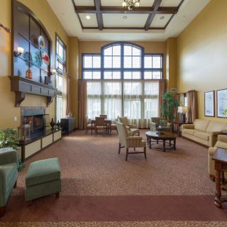 A spacious lobby with comfortable seating, large windows, and a fireplace.