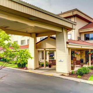 A welcoming hotel entrance with a covered driveway and landscaped surroundings.