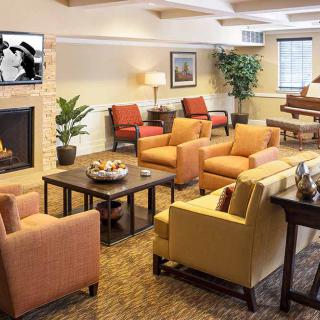 A cozy living room with comfortable seating, a fireplace, and a piano.