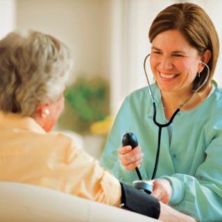 A nurse checks an elderly patient's blood pressure.