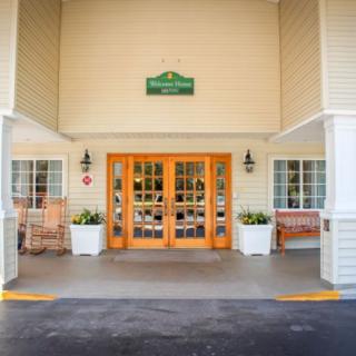 Entrance to a hotel or resort with double wooden doors and potted plants.