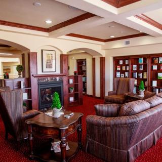 A cozy living room with a fireplace and bookshelf, featuring comfortable couches and elegant decor.