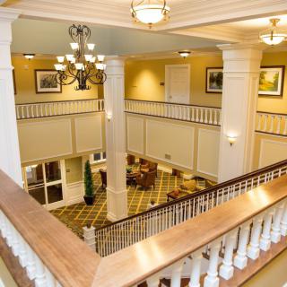 A grand hotel lobby with elegant columns and a chandelier.