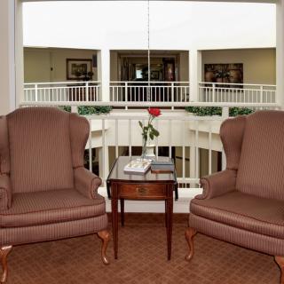 A cozy seating area with two armchairs and a table overlooking a balcony.