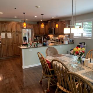 A spacious kitchen and dining area with wooden cabinetry, a central island, and a dining table set with chairs.
