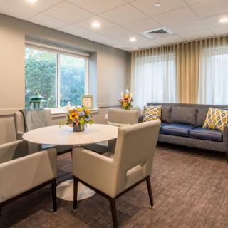 A cozy lounge area with comfortable seating and natural light from large windows.