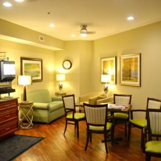 A cozy living room with seating and a dining area, enhanced by warm lighting and decor.