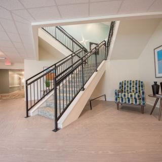 Modern lobby with a central staircase and seating area.