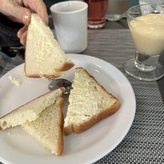 A simple breakfast with buttered toast, coffee, and juice.