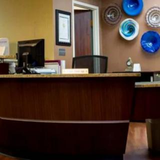 A reception area with a wooden desk and decorative wall art.