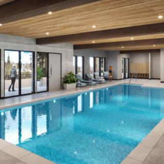 A modern indoor swimming pool with ample natural light and stylish design.
