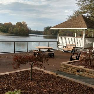 A peaceful lakeside view with a gazebo and seating area.