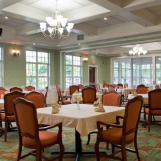 A spacious dining room with elegantly set tables and comfortable seating.
