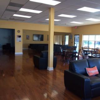 A spacious lounge area with comfortable seating and wooden flooring.
