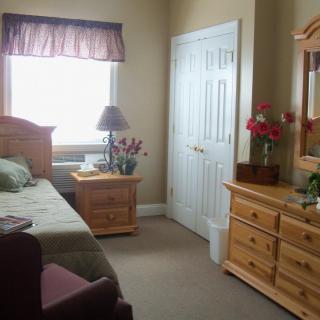 A cozy bedroom with wooden furniture and decorative flowers.