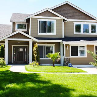 A modern two-story suburban house with a well-maintained lawn.