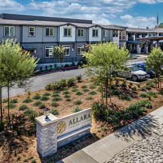 A modern residential building with landscaped surroundings and clear skies.