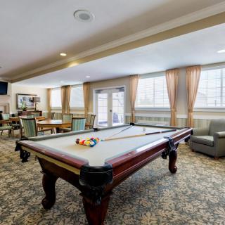 A cozy game room featuring a pool table and comfortable seating.