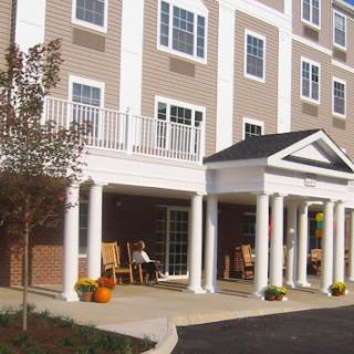 A welcoming residential building featuring classical architecture with columns and a front porch.