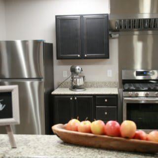 A modern kitchen with stainless steel appliances and a bowl of apples on the countertop.