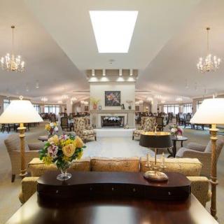 A spacious and elegantly furnished living room with multiple seating areas and a central fireplace.