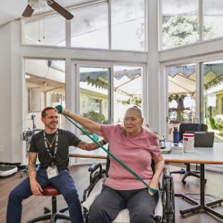 A patient engages in physical therapy with the assistance of a caregiver, focusing on rehabilitation and wellness.