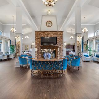 Luxurious lounge area with elegant seating, chandeliers, and a central fireplace.