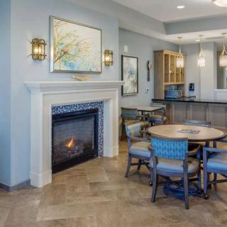A modern living area featuring a fireplace, round table with chairs, and contemporary artwork.