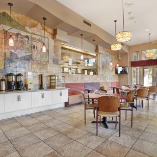 A cozy restaurant interior with tables, chairs, and decorative murals.