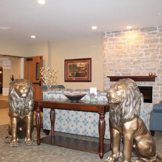 A stylish lobby featuring decorative lion statues flanking a wooden console table.