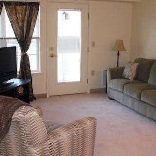 A cozy living room with a sofa, TV, and natural lighting.