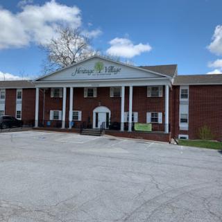 A view of a brick building with columns under a clear blue sky.