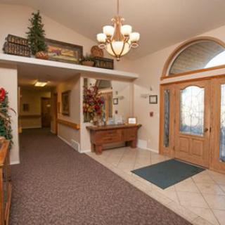 A welcoming foyer with a chandelier, decorative elements, and a combination of carpeted and tiled flooring.