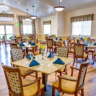 A brightly lit restaurant dining area with neatly arranged tables and chairs, ready for guests.