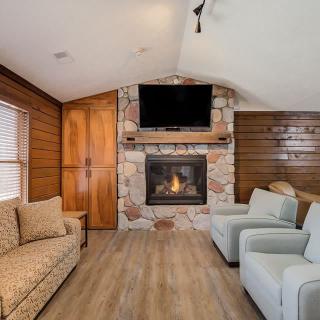 A cozy living room with a stone fireplace and comfortable seating.