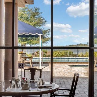 A peaceful dining area with a view of the pool and patio through large windows.