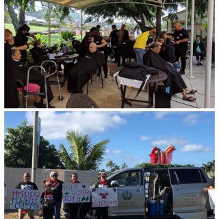 A group of people gather in protest, holding signs outdoors.