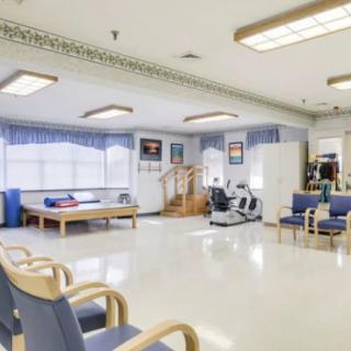 A spacious rehabilitation center with exercise equipment and a waiting area.