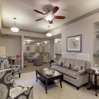 A cozy living room with a sofa, coffee table, and elegant lighting fixtures.