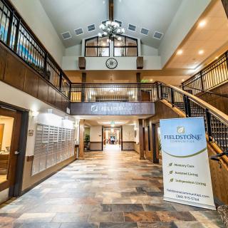 A spacious and elegantly designed lobby with a grand staircase and a welcome sign.