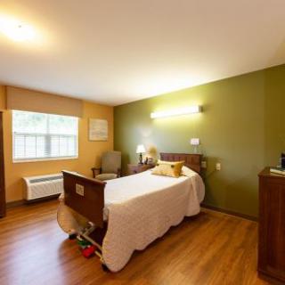 A cozy and well-lit bedroom with a wooden bed and warm color accents.